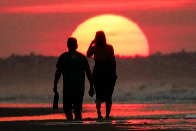 May 20, 2025, Isle Of Palms, Sc, United States: A couple, silhouetted by the sunrise walks toward the sun as it rises over the horizon at Front Beach, May 20, 2025 in Isle of Palms, South Carolina. Isle Of Palms United States - ZUMAe02_ 20250520_zaf_e02_003 Copyright: xRichardxEllisx
