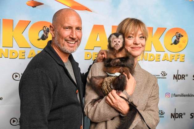 AKIKO DER FLIEGENDE AFFE Heike Makatsch and Benno Fürmann Fuermann with little monkeys cuddling in their arms as guests on the red carpet at the movie premiere Akiko der fliegende Affe at the Kino Filmtheater am Friedrichshein 25 05 2025 in BERLIN Berlin Germany