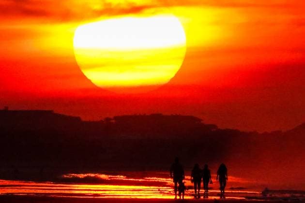 May 29, 2025, Isle Of Palms, Sc, United States: The sun rises over Front Beach on a humid, hazy morning silhouetting people walking along the coast, May 29, 2025 in Isle of Palms, South Carolina. Isle Of Palms United States - ZUMAe02_ 20250529_zaf_e02_001 Copyright: xRichardxEllisx