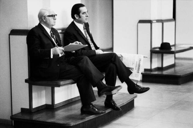 Hamburg, January 1972 Two Men in Suit and Tie sit side by side at a Finishing Wooden bench on Edge of Trading floor the Hamburg Stock Exchange the Left Man is white-haired, carries a Glasses and holds a Notebook Or Stock exchange directory in the Hands the younger Man next to him with combed back Hair Copyright: xUnitedxArchivesx xSvenxSimonxArchives SVS_94010000629