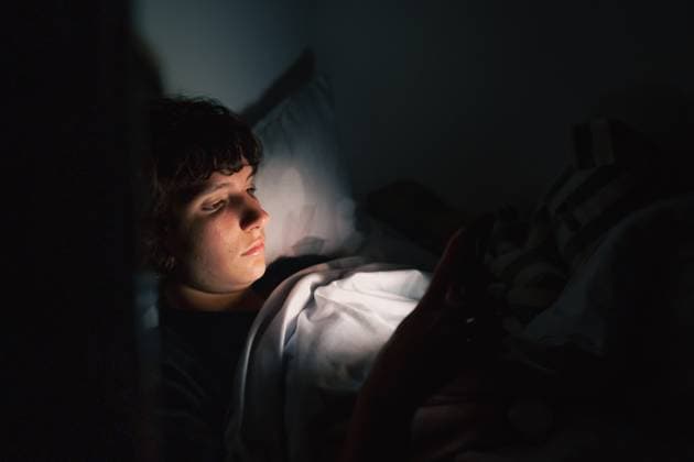 Teenager benutzt Gadget im Dunkeln teenager uses gadget in dark. Teen girl, lying under covers in bed, uses mobile phone, at night (License=RF) ,model released, Symbolfoto Copyright: xZoonar.com LarysaxStefaniukx 23623617 ,model released, Symbolfoto ,property released