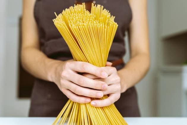 Koch mit Spaghetti in der Hand Woman in brown chef s apron holding spaghetti close-up. Chef holding spaghetti (License=RF) ,model released, Symbolfoto Copyright: xZoonar.com LarysaxStefaniukx 23639107 ,model released, Symbolfoto ,property released