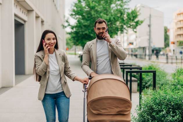 Mother and father with child in stroller talking on mobile phones while walking in the city model released, Symbolfoto, VSNF03424