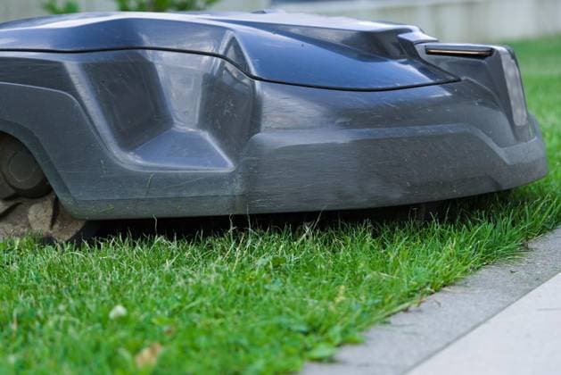 Lawn care through Lawn cut with Mähroboter Close-up Lawn robot 1077406145