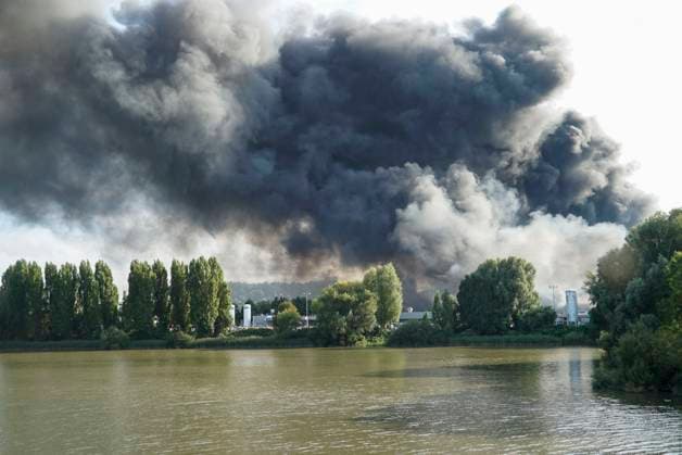 cntv large fire fire smoke smoke flames firefighters ambulance in action during rescue care of one of the seriously injured who may have been injured by flying debris large fire In the industrial area on the Peute at least 3 warehouses have caught fire cause unclear fire department gives 5 alarm 25 08 2025 Hamburg Veddel Hamburg Germany