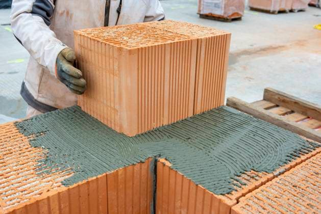 A residential building is built with bricks The shell of a residential building in a new development is built with bricks, as a symbolic image for housing construction and housing policy