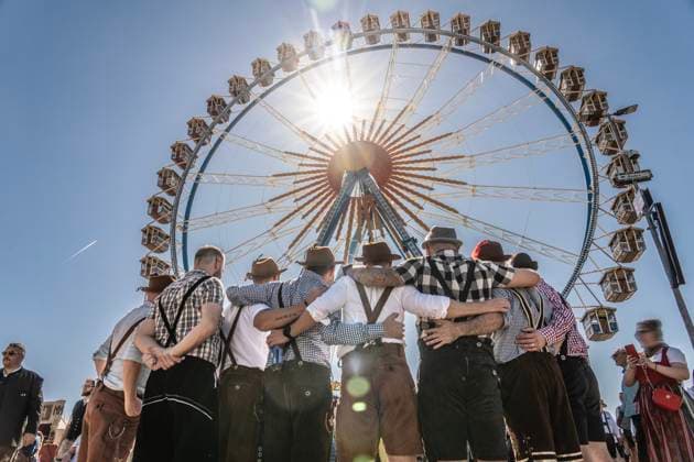 Oktoberfest 2025, Wiesn start in bright sunshine and temperatures up to 30 degrees, men in traditional costume taking a group photo in front of the Ferris wheel, September 20, 2025 Germany, Munich, September 20, 2025, Oktoberfest 2025, group of men in traditional Bavarian costume take a photo