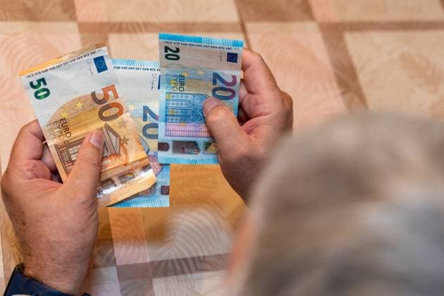 Germany - September 21, 2025: An elderly man holds 50 and 20 euro notes in his hands. The image symbolizes financial security in old age and represents the topics of pensions, retirement provisions, and receiving pension payments.