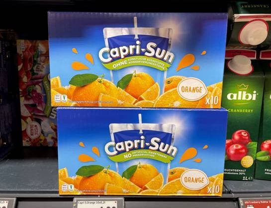 Here is a view of two packs of Capri Sun drink, orange, 10 pieces, in the supermarket, discounter