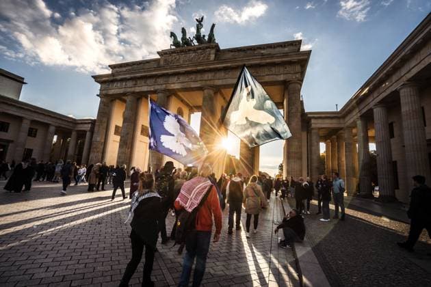 Day of German Unity, Peace flags shine symbolically in the evening sun at the Brandenburg Gate, Berlin, October 3, 2025 Germany, Berlin, October 3, 2025, Day of German Unity, Peace flags shine symbolically in the evening sun at the Brandenburg Gate, Demonstrators of an already ended Pro Gaza peace demo walk across Pariser Platz, Peace, Politics,