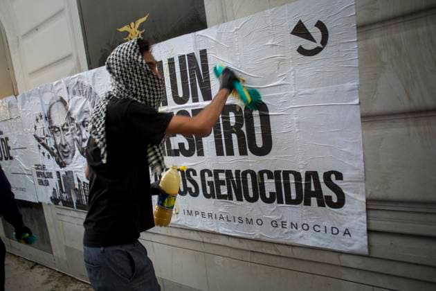 October 4, 2025, Madrid, Madrid, Spain: A protester, his face covered by a keffiyeh, pastes a mural.against genocide, during a pro-Palestinian demonstration in central Madrid in solidarity with the Palestinian people in the face of Israeli attacks and condemning the interception by Israeli forces of the Global Sumud Flotilla ships. Madrid Spain - ZUMAs296 20251004_znp_s296_007 Copyright: xLuisxSotox