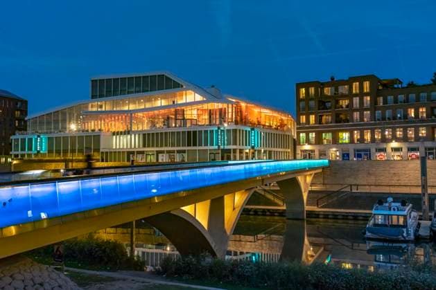 City harbor Venlo Primark at Maasboulevard and illuminated bridge over the city harbor in Venlo at dusk, Netherlands Primark at Maasboulevard and the illuminated Marina bridge in Venlo at dusk, Netherlands