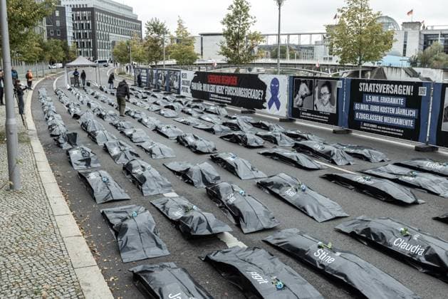 Protest action by the patient organization Kinder ME CFS in front of the Federal Ministry of Research, Technology and Space Germany, Berlin on 15 10 2025 100 body bags in front of the BMFTR as a silent visualization of the humanitarian catastrophe Quote Black body bag with first names and the banner in the background ME CFS,