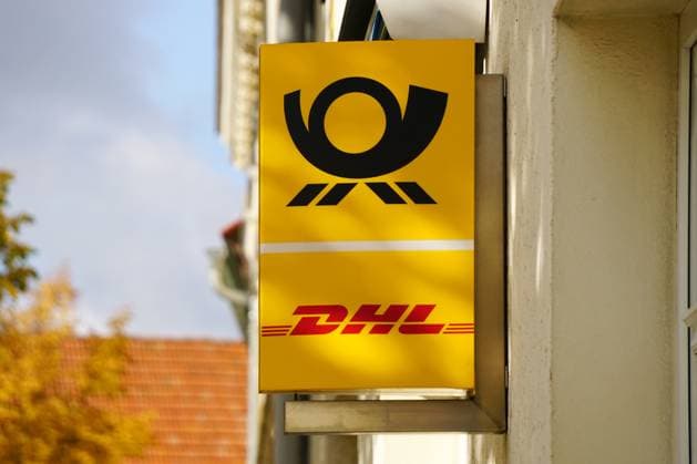 Parcel acceptance, DHL Advertising sign with Post symbol on Entrance a Postal branch 1131606006