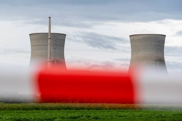 Gundremmingen, Bavaria, Germany - October 25, 2025: The nuclear power plant on the day the cooling towers of the decommissioned Gundremmingen nuclear power plant (AKW KRB) in Bavaria were blown up. The two 160-metre-high towers will be blown up at 12 noon on Saturday, October 25, 2025. Symbolic photo nuclear phase-out, barrier tape and warning beacon in the foreground, the nuclear power plant in the background
