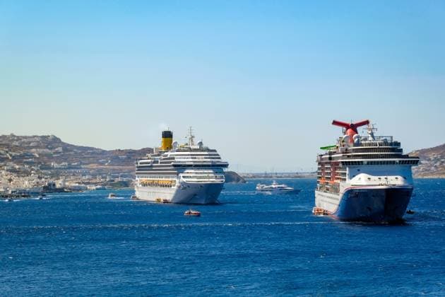 Mykonos, Cyclades, Greece Cruise ships CARNIVAL MIRACLE and COSTA FORTUNA moored in the bay off Mykonos town Old town with the windmills Tender boats bring tourists to the shore Mykonos Mykonos Greece