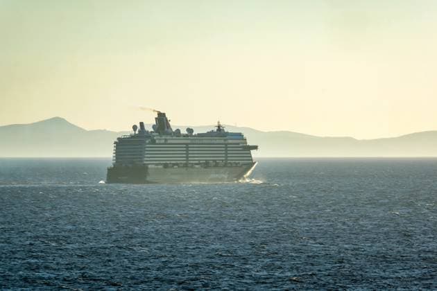 Mykonos, Cyclades, Greece Cruise ship MEIN SCHIFF 5 leaves the harbor bay of Mykonos and leaves behind a dark cloud of exhaust fumes Mykonos Mykonos Greece