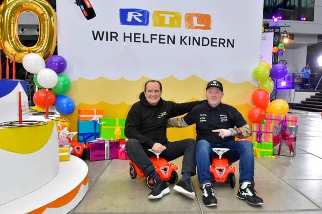 abb presenter Wolfram Kons and Joey Kelly musician athlete in the Bobbycar slide cars in the RTL studio at the photo session for the 24 hour charity birthday challenge 30th birthday of the RTL Spendenmarathon wir helfen Kindern bei RTL Deutschland on 19 11 2025 in Cologne Deutz NRW Germany