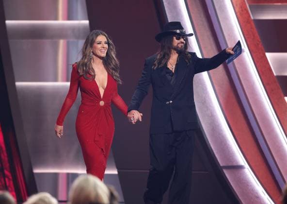 (L-R) Elizabeth Hurley and Billy Ray Cyrus appear onstage during the 59th CMA Awards at the Bridgestone Arena in Nashville, Tennessee, on Wednesday, November 19, 2025.  NAS20251119281 JOHNxANGELILLO