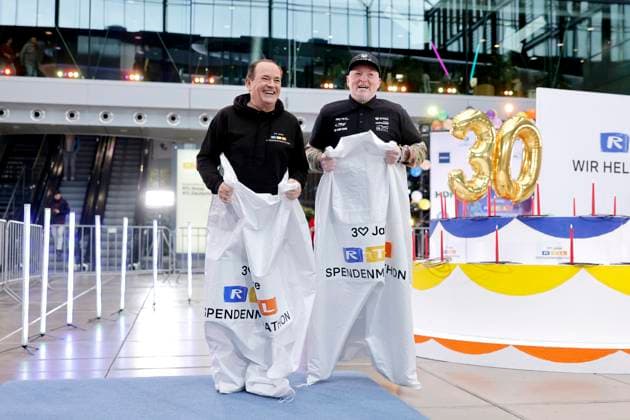 Presenter Wolfram Kons and singer Joey Kelly doing a sack race at a photo session to mark 30 years of the RTL telethon in the RTL building at Picassoplatz Cologne, 19 11 2025 NRW Germany Copyright: xChristophxHardtx