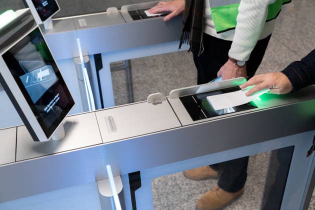 Munich, Bavaria, Germany - November 25, 2025: Trial operation for the new boarding gate in Terminal 1 at Munich Airport. Volunteers test processes ahead of the planned opening in 2026. Travelers hold their printed boarding passes ready for electronic scanning at the self-boarding gate