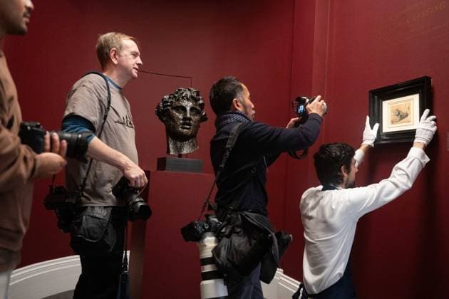 November 28, 2025, London, England, United Kingdom: Photographers capture Rembrandt Harmensz. van Rijn s Young Lion Resting , estimated at 15,000,000-20,000,000 GBP, during a photo call at Sothebys in London, as a Sotheby s art handler holds the work. George Frederic Watts, O.M., R.A. Physical Energy sculpture can be seen in the background. London United Kingdom - ZUMAk172 20251128_zip_k172_054 Copyright: xThomasxKrychx