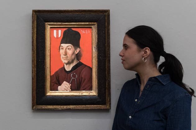 November 28, 2025, London, England, United Kingdom: A staff member looks at a painting titled Portrait of the architect Moritz Ensinger (c. 1430Ã¢â‚¬1482 3) by South German School, probably Ulm, early 16th century, estimate: 100,000 - 150,000 GBP during a photocall at Sotheby s auction house ahead of Old Master & 19th Century Paintings Sales. London United Kingdom - ZUMAs371 20251128_zip_s371_009 Copyright: xWiktorxSzymanowiczx