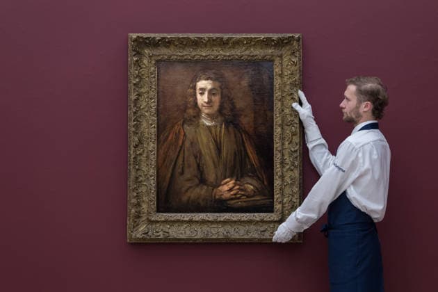 November 28, 2025, London, England, United Kingdom: An art handler holds a painting titled Saint John on Patmos, half-length, his folded hands resting on the cover of a book, a palm tree behind him and his emblem of an eagle to the right,.his head based on the features of Titus van Rijn by Rembrandt Harmensz. van Rijn, estimate: 5,000,000 - 7,000,000 GBP during a photocall at Sotheby s auction house ahead of Old Master & 19th Century Paintings Sales. London United Kingdom - ZUMAs371 20251128_zip_s371_023 Copyright: xWiktorxSzymanowiczx
