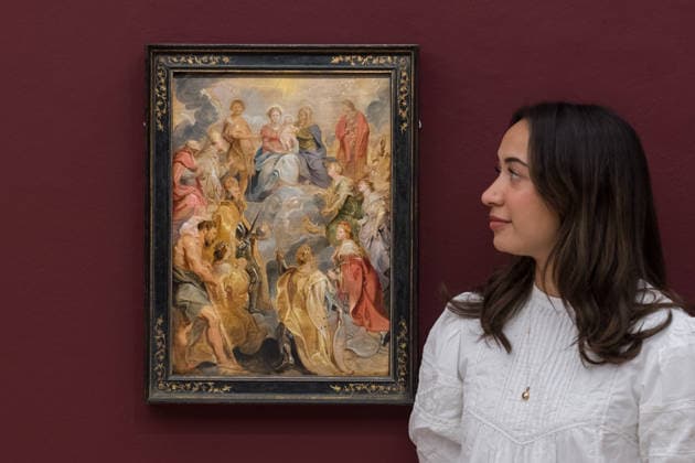 November 28, 2025, London, England, United Kingdom: A staff member looks at a painting titled The Virgin and Child with Saint Anne adored by Saints of the House of Habsburg by Sir Peter Paul Rubens, estimate: 2,000,000 - 3,000,000 GBP during a photocall at Sotheby s auction house ahead of Old Master & 19th Century Paintings Sales. London United Kingdom - ZUMAs371 20251128_zip_s371_026 Copyright: xWiktorxSzymanowiczx