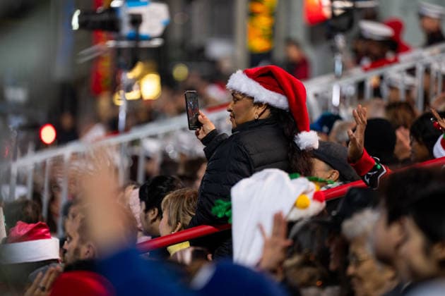 HOLLYWOOD, CALIFORNIA - NOVEMBER 30: A woman wearing a Christmas hat watches the 93rd Annual Hollywood Christmas Parade on November 30, 2025 in Hollywood, California.  Copyright: xVCGx 111606900228