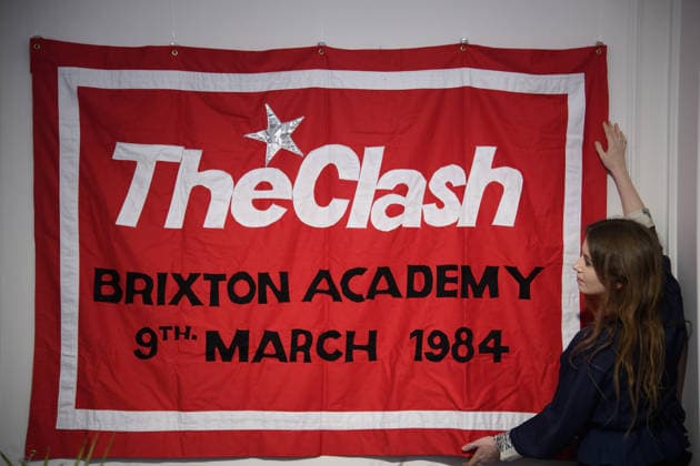 Bonhams Sound & Cinema: With Property from The Marianne Faithfull Estate Sale - Bonhams, London, UK - 1 December 2025 A staff member views Louis Theroux s First Concert - sewn cotton red banner, with The Clash Brixton Academy 9th March 1984 embroidered to centre of banner by Jeremy Deller x Louis Theroux (est. £8k - £10k) which is on auction at Bonhams Sound & Cinema: With Property from The Marianne Faithfull Estate Sale ending from 3rd December 2025 at Bonhams in London, England, UK on Monday 1 December, 2025., Credit:Justin Ng Avalon UK, England, London, Bonhams Copyright: xJustinxNgx xAvalonx 1055809936