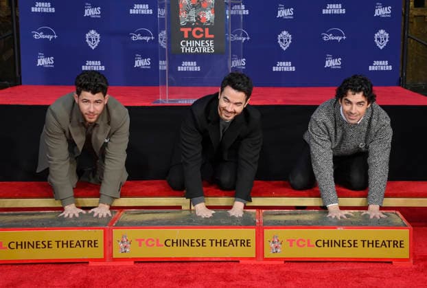 (L-R) Nick Jonas, Kevin Jonas and Joe Jonas of the Jonas Brothers participate in a hand and footprint ceremony immortalizing them in the forecourt of the TCL Chinese Theatre (formerly Grauman s) in the Hollywood section of Los Angeles on Wednesday, December 3, 2025.  LAP2025120303 JIMxRUYMEN