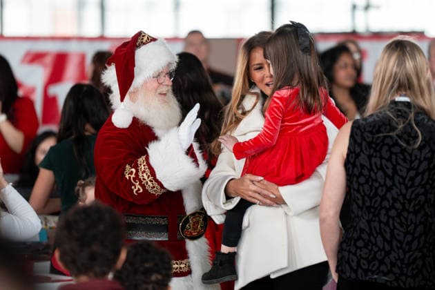 December 8, 2025, Quantico, Virginia, USA: First Lady MELANIA TRUMP lifts a young girl into her arms so she can high five and speak with Santa Claus during a Toys for Tots event at Marine Corps Base Quantico. Quantico USA - ZUMAs365 20251208_znp_s365_007 Copyright: xJoeyxSussmanx