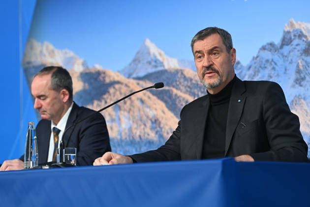 From left Hubert AIWANGER Free Voters, Bavarian Minister of Economic Affairs, Markus SOEDER State Premier of Bavaria and CSU Chairman in front of a wintry Alpine backdrop, press conference of the Bavarian State Government after the cabinet meeting on 16 12 2025 in the Prinz Carl Palais in Munich