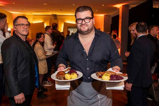 abb Gregor Nebel as celebrity waiter serving plates with Gaensekeuele red cabbage and dumplings at the 31 Frank Zander Christmas Party Christmas Dinner for Homeless and Needy People 2025 at Estrel Convention Center on December 22, 2025 in Berlin Berlin Germany