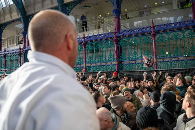 December 24, 2025, London, United Kingdom: A joint of meat is thrown to a member of the public during the annual Smithfield Market Christmas Eve auction. Members of the public attend the annual Smithfield Market Meat Auction. Held every Christmas eve, the tradition organised by individual suppliers, butchers and porter™s auction off surplus prime cuts of meat at a reduced price. The 900-year-old market situated in the City of London faces an uncertain future as the site has been marked for re-development with the market being moved to another of part of London. London United Kingdom - ZUMAs197 20251224_aaa_s197_139 Copyright: xJamesxWilloughbyx