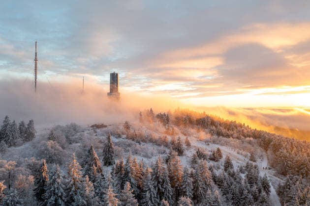 Winter evening in the Taunus The summit of the Großer Feldberg in the Taunus rises out of the high fog at sunset , Schmitten Hessen Germany
