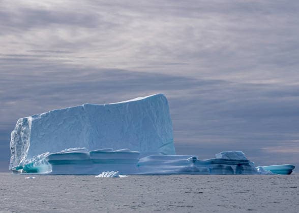 17 08 2025, Iceberg floats and floats on the water An iceberg with different shapes and colors floats on the water Depending on the irradiation of the light, the color of the water or the ice also changes