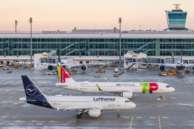 Munich Airport in snowy operation during cold spell in Bavaria, Oberding, 11 01 2026 Two aircraft of Lufthansa and TAP Air Portugal are parked at the terminal of Munich Airport The photo shows aircraft of both airlines in close proximity a visual symbol of the strategic proximity of the airlines in the con 20260111-286A6236-M4000