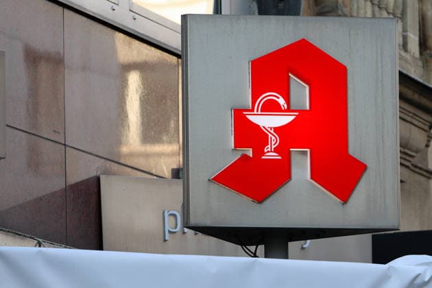 Pharmaceuticals from the pharmacy A pharmacy logo can be found on the façade of a building