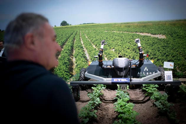 Gruene Woche Berlin DEU, Deutschland, Germany, Berlin, 23.01.2026 Modell einer Erntemaschine AI Land vor Foto Feld mit Kartoffeln fuer eine industrielle Landwirtschaft zum Thema Kuenstliche Intelligenz KI in der Halle vom Bundesministerium fuer Landwirtschaft Ernährung und Heimat zum Thema Ernaehrungssicherheit und oekologische Landwirtschaft vom Forum Moderne Landwirtschaft auf der Messe der Internationalen Gruenen Woche unter dem Motto Tradition trifft Zukunftsvisionen Gutes Essen Starkes Land Zukunftsfeste Landwirtschaft 100 Jahre 1926 - 2026 in Berlin Deutschland . Die Internationale Gruene Woche Berlin ist eine internationale Verbrauchermesse und Ausstellung der Ernaehrungswirtschaft Landwirtschaft Gartenbau und fuer landwirtschaftlic