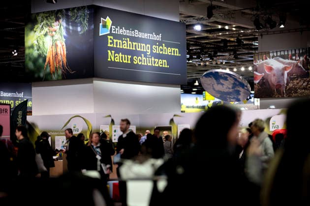 Gruene Woche Berlin DEU, Deutschland, Germany, Berlin, 23.01.2026 Besucher vor Logo Erlebnis Bauernhof Ernaehrung Ernährung sichern Natur Schuetzen Schützen zum Thema Ernaehrungssicherheit und oekologische Landwirtschaft in der Biohalle vom Forum Moderne Landwirtschaft auf der Messe der Internationalen Gruenen Woche unter dem Motto Motto Tradition trifft Zukunftsvisionen Gutes Essen Starkes Land Zukunftsfeste Landwirtschaft 100 Jahre 1926 - 2026 in Berlin Deutschland . Die Internationale Gruene Woche Berlin ist eine internationale Verbrauchermesse und Ausstellung der Ernaehrungswirtschaft Landwirtschaft Gartenbau und fuer landwirtschaftliche Produkte aus aller Welt. Die Messe gibt aktuellen gesellschaftlichen Fragen wie Klimaschutz Kreisl
