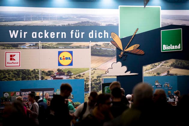 Gruene Woche Berlin DEU, Deutschland, Germany, Berlin, 23.01.2026 Besucher am Stand von Kaufland und Lidl in der Biohalle von Bioland mit Logo Wir ackern fuer dich zum Thema Ernaehrungssicherheit und oekologische Landwirtschaft in der Biohalle vom Forum Moderne Landwirtschaft auf der Messe der Internationalen Gruenen Woche unter dem Motto Tradition trifft Zukunftsvisionen Gutes Essen Starkes Land Zukunftsfeste Landwirtschaft 100 Jahre 1926 - 2026 in Berlin Deutschland . Die Internationale Gruene Woche Berlin ist eine internationale Verbrauchermesse und Ausstellung der Ernaehrungswirtschaft Landwirtschaft Gartenbau und fuer landwirtschaftliche Produkte aus aller Welt. Die Messe gibt aktuellen gesellschaftlichen Fragen wie Klimaschutz Kreisla