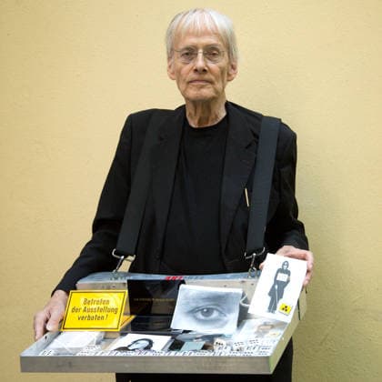 Timm Ulrichs with a vendors tray filled with his multiples in the courtyard of Potsdamer Straße 73 at Peter Fabians Verlag Artikel Editionen , 19 8 2019