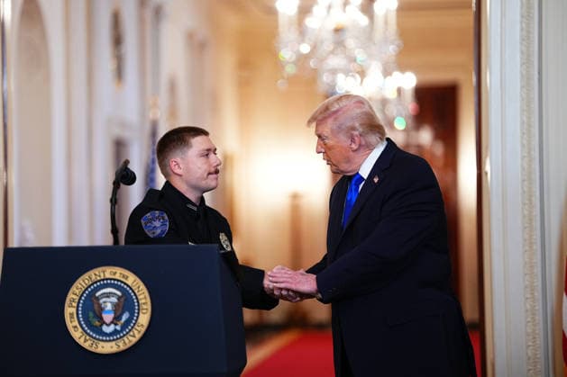 President Donald Trump shakes hands with former NYPD Officer Ethan Curreri, who arrested Jose Ibarra for child endangerment before he murdered Laken Riley, during an Angel Families Remembrance Ceremony in the East Room of the White House in Washington, DC on Monday, February 23, 2026. Trump signed a proclamation declaring February 22 as Angel Family Day to honor families who have lost loved ones to crimes committed by individuals in the country illegally or undocumented immigrants. WASP20260223103 AaronxSchwartz
