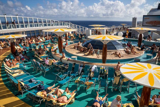 Relaxing on deck on the high seas Passengers on an AIDAblu cruise ship enjoy the voyage through the Caribbean St John s Antigua and Barbuda on the sun deck