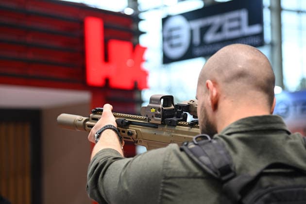 Visitors at the booth of HK, Heckler and Koch, assault rifles at the ready, weapons, rifle firearms The Enforce Tac as Germanys leading trade fair for security and defense from 23 25 02 2206 at the Nuremberg Exhibition Center