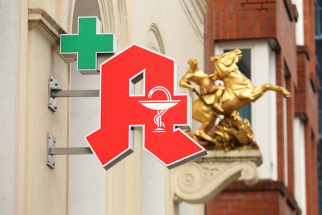 A pharmacy A hangs on the facade of a pharmacy in Lange Reihe Behind it, a gold sculpture has been attached to the facade St Georg Hamburg