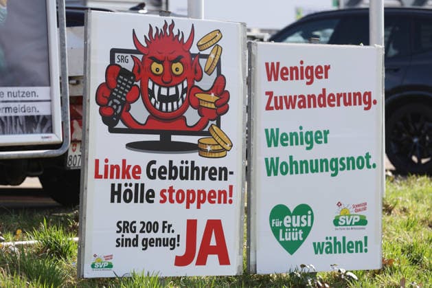 25 02 2026 Ruemlang ZH, SWITZERLAND, A Yes poster for the SRG initiative halving initiative on the roadside and an SVP poster Less immigration, less housing shortage