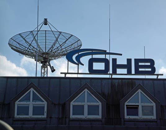 Der auf mehrere Gebäude verteilte Hauptstandort des Technologie- und Raumfahrtkonzerns OHB SE im Technologiepark am Rande der Universität Bremen. OHB produziert unter anderem militärische und zivile Satelliten. Haupteigentümerin ist die Familie der Firmengründerin Christa Fuchs und ihres 2014 gestorbenen Mannes Manfred Fuchs. Ihr Sohn Marco R Fuchs ist seit 2000 Vorstandsvorsitzender. 1981 82 hatte die Kauffrau Christa Fuchs einen kleinen Reparaturbetrieb für die Bundesmarine namens Otto Hydraulik Bremen (OHB) übernommen, mit damals nur fünf Beschäftigten. Zusammen mit ihrem Mann entwickelte sie den Betrieb zu einem Konzern, der 2025 über 3.000 Mitarbeitende an 15 Standorten beschäftigte. Im Herbst 2024 stieg die US-amerikanische